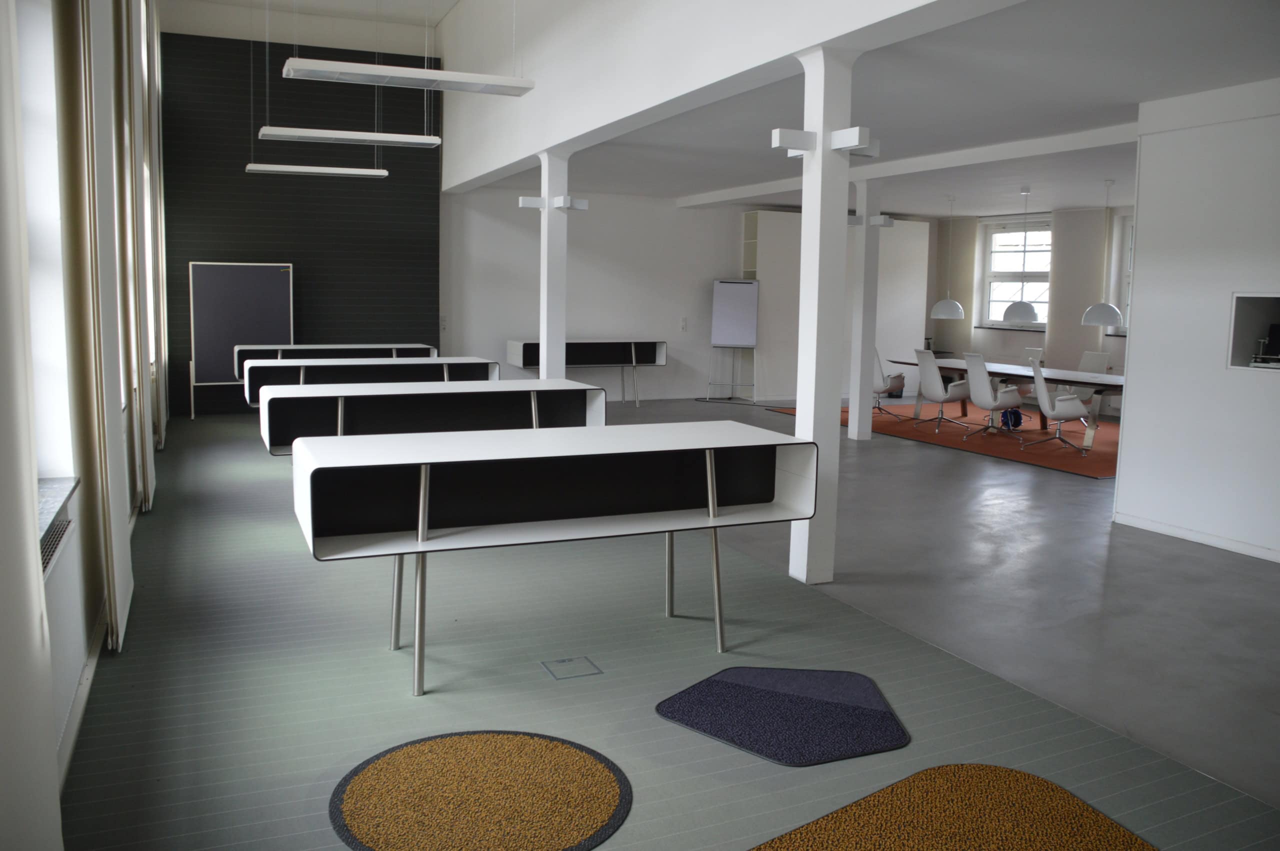 Helles Büro mit Konferenz- und Cafeteria-Bereich, flexible Arbeitsplätze.