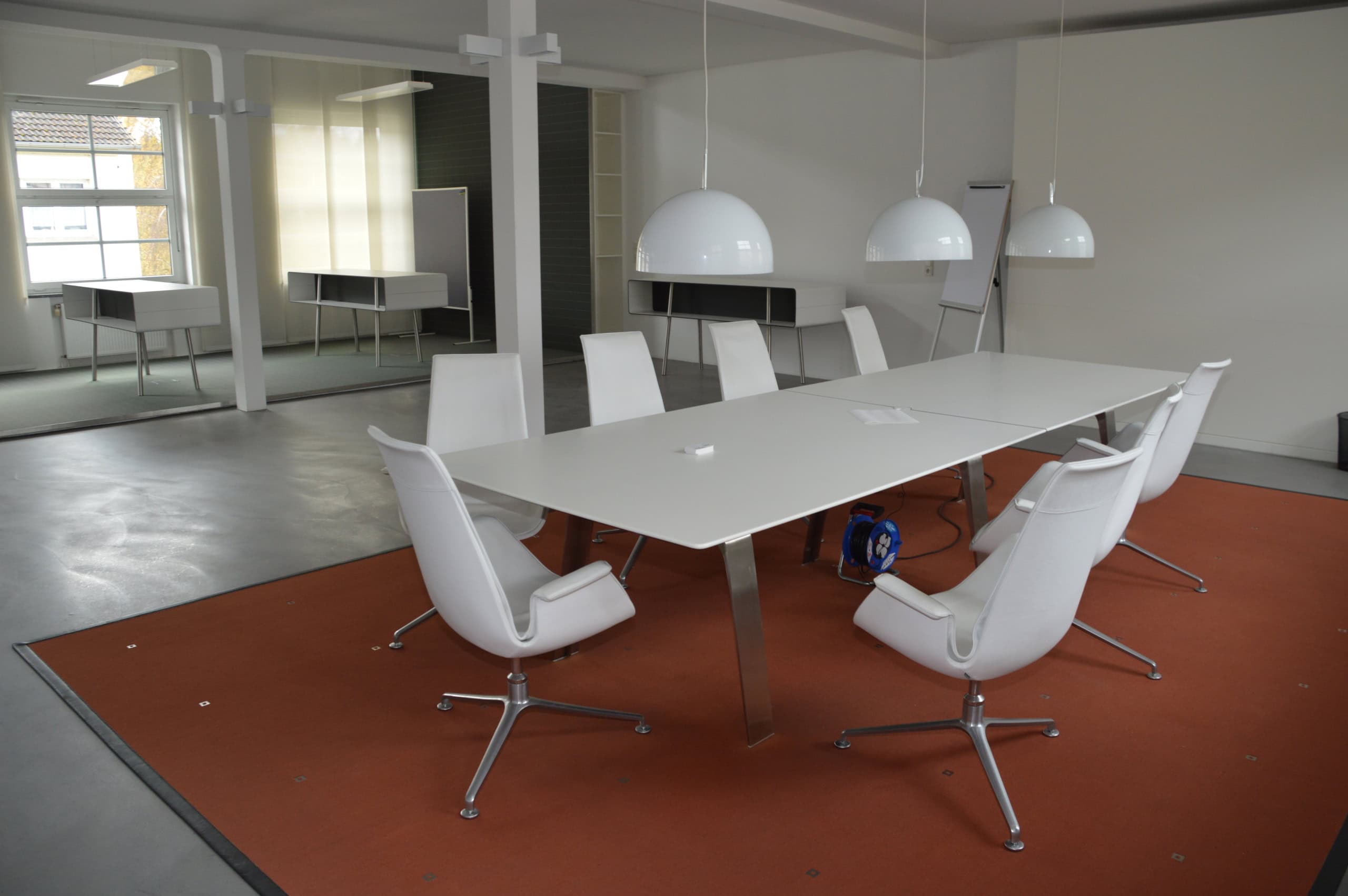 Helles Büro mit Konferenz- und Cafeteria-Bereich, ideal für Meetings und Zusammenarbeit.