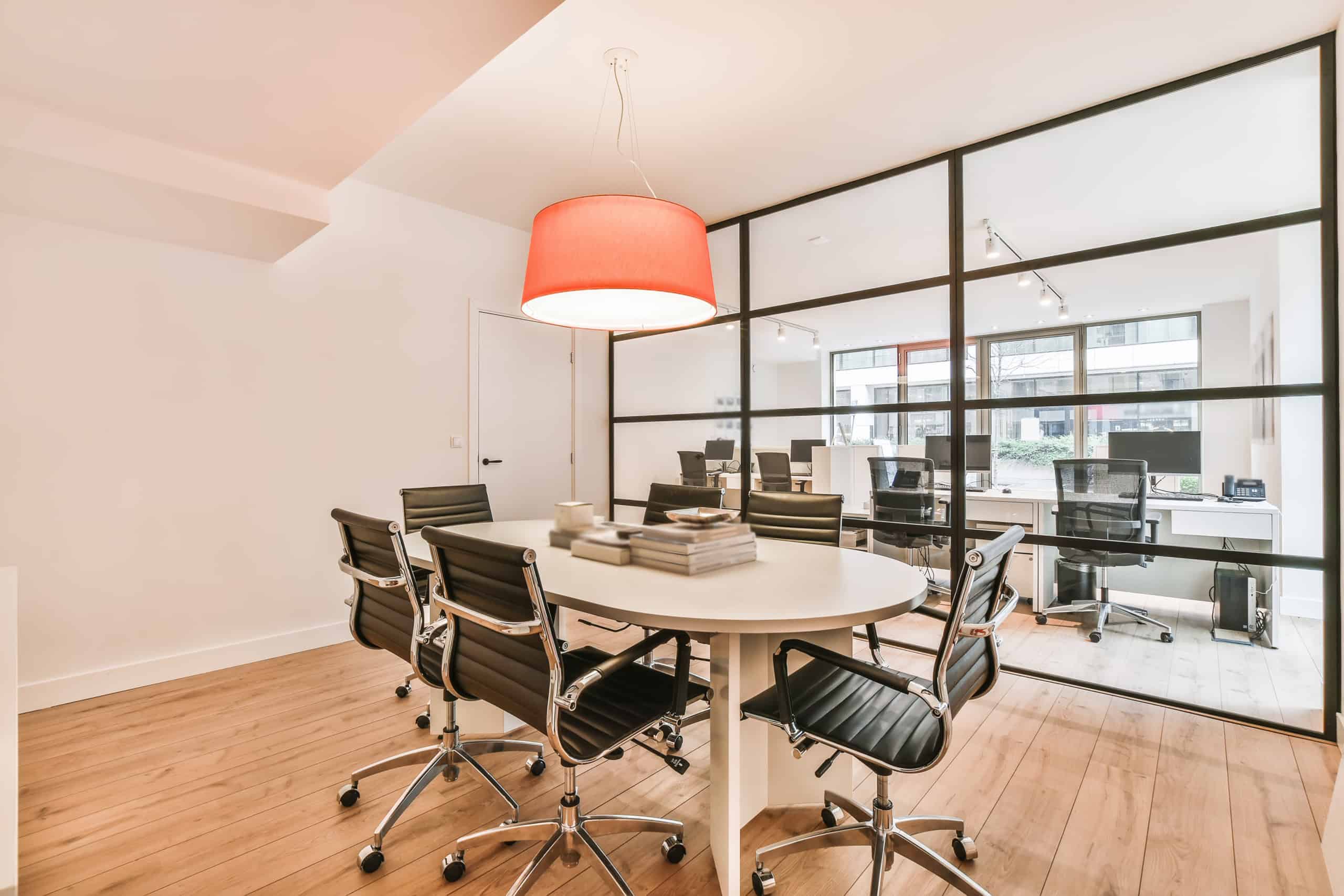 Attraktives Büro mit Besprechungstisch, ergonomischen Stühlen und großem Fenster für produktives Arb.